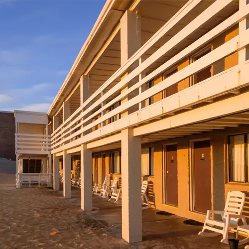 The second-floor balcony walkway running the length of the building, lit by the golden-hour sun