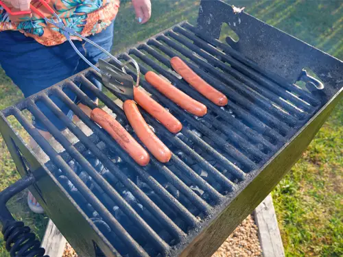 Hot dogs grilling on one of the property’s charcoal grills in the picnic area