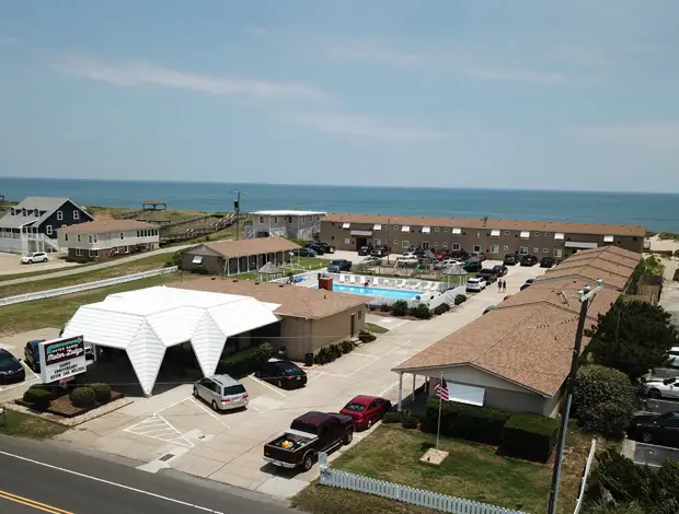 An aerial view of the motel from Virginia Dare Trail, showing the office, the pool and the ocean beyond