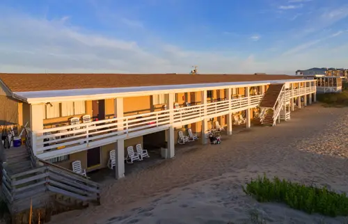 The Outer Banks Motor Lodge, a two-storey motel directly on the beach, with white railings and dune grass in front