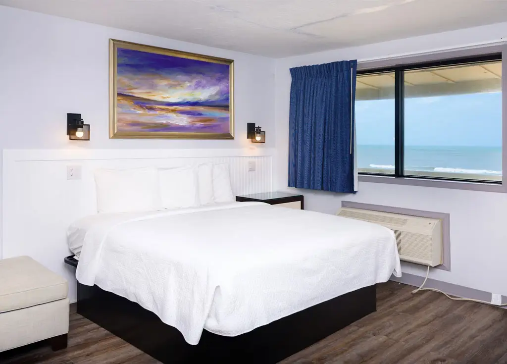 King bed beside an ocean-view window in a second-floor room