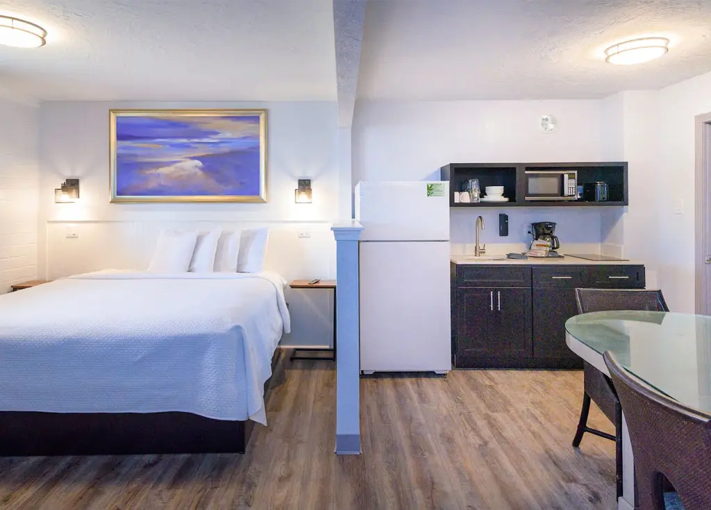 Queen bed beside the kitchen in an oceanfront three-room apartment
